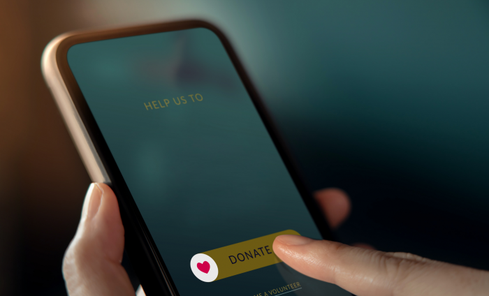 A phone with a tab saying 'donate' and a finger about to press it. 